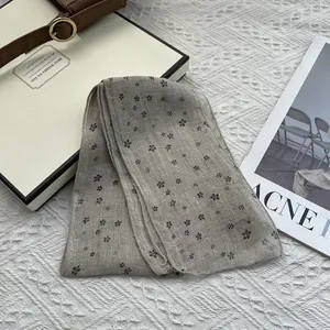 Macro detail of breathable linen scarf showing floral print and natural woven texture
