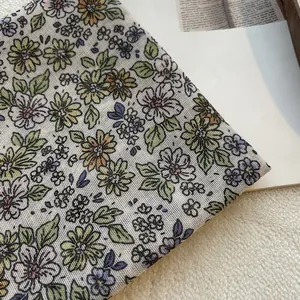 Vista dettagliata del tessuto a stampa floreale con margherite gialle e fiori viola