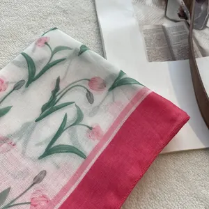 Detail of floral cotton scarf showing pink tulips and delicate pink stitched edges