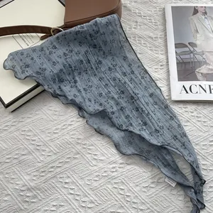 Detail of blue floral cotton linen triangle scarf with stitched edges and care label