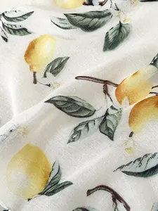 Gros plan sur la texture du lin avec motifs réalistes de citrons jaunes et feuilles