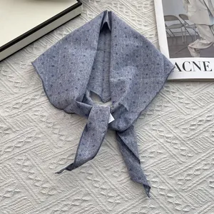 Detailed flat lay of blue floral cotton linen scarf with small diamond pattern prints