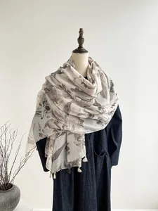 Detailed view of floral linen silk scarf with tassel edges on a mannequin