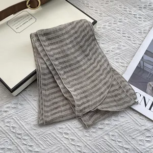 Texture detail of a pure linen striped scarf in coffee and beige with a soft fabric feel