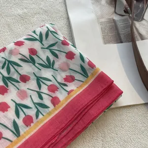 Detail of floral cotton linen headscarf with red tulips on soft mesh fabric