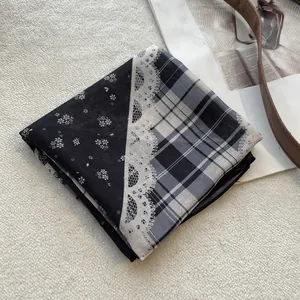 Detail van een vintage patchwork sjaal met bloemen-, kant- en grijs ruitjespatroon