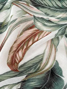Detailansicht eines dünnen Schals mit tropischen Palmenblättern und Fransen-Textur