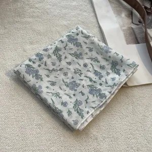 Close-up of small floral linen square scarf with delicate purple flowers and neat edges