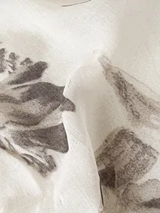 Macro shot showing detailed linen texture and vintage plant prints on a gray-white scarf