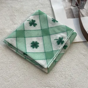 Close-up of green clover pattern cotton scarf with detailed overlock stitched edges