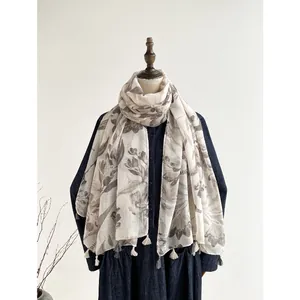 Elegant grey-white cotton linen floral scarf with tassels shown on a female mannequin