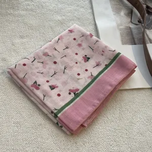 Detail of floral cotton linen scarf with cherry blossom pattern and striped edges