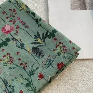 Vista dettagliata di un foulard in cotone e lino verde salvia con motivi floreali