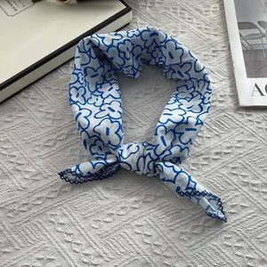Close-up of floral cotton scarf with blue line art flowers and delicate lace trim