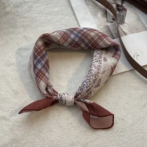 Detailopname van vintage zijden sjaal met ruit- en bloemmotieven en fijne afwerking