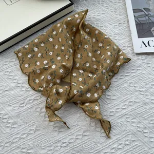 Detail of floral cotton linen headscarf in ginger yellow with small white flowers