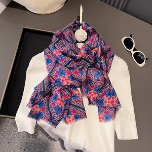 Écharpe bohème à motif paisley et franges drapée sur un pull blanc style ethnique
