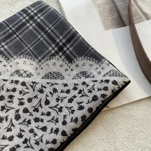 Detailweergave van een vintage sjaal met ruit- en bloemenpatchwork op wit pluche