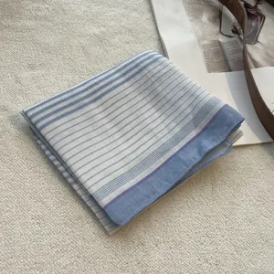 Detailed view of the blue and white striped cotton neckerchief on a soft white background