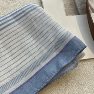 Close-up of blue and white striped linen square scarf with delicate purple edge stitching