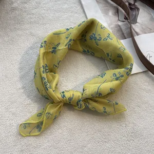 Detail of yellow cotton floral bandana showing the soft texture and floral print detail
