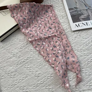 Detail of pink floral cotton linen triangle headscarf with scalloped edges on knit background