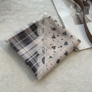 Detail van vintage vierkante sjaal met ruitjes, bloemenprint en kantafwerking