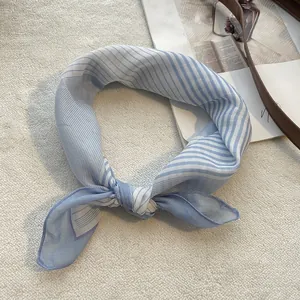 Detail of blue and white striped cotton linen square scarf tied in a stylish knot