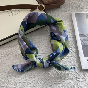 Carré de soie à motif camouflage sur tissu texturé blanc avec accessoires de mode