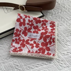 Close-up of floral cotton scarf with intricate lace trim and red flower print