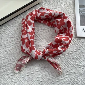Detailed view of red floral cotton scarf featuring delicate white lace edge trim