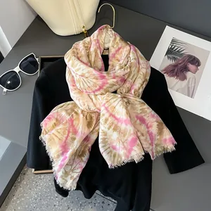 Dettaglio di sciarpa tie-dye rosa e beige con frange su uno sfondo moda piatto ed elegante
