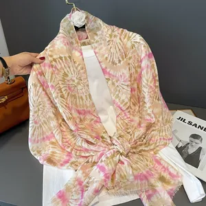 Dettaglio della trama tie-dye rosa e beige su questo scialle estivo leggero