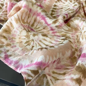 Dettaglio della sciarpa tie-dye rosa e verde oliva con pieghe morbide e trama