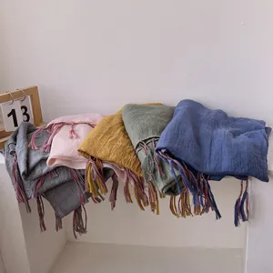 Detailed macro view of wrinkled cotton linen scarves with colorful fringe in multiple shades
