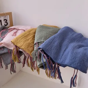 Detailed stack of multi-color cotton linen scarves with hand-woven tassel edges