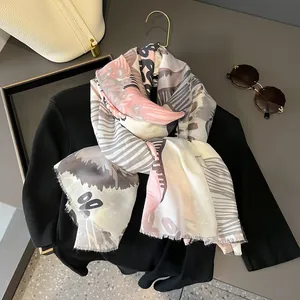 Détail d'un foulard en soie avec motifs abstraits et bords délicatement frangés