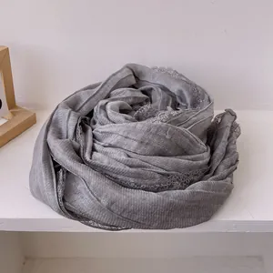 Close-up of dark grey cotton linen scarf featuring delicate lace trim detail
