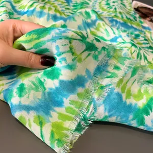 Dettaglio di uno scialle da spiaggia tie-dye leggero con trama morbida e bordi a frange