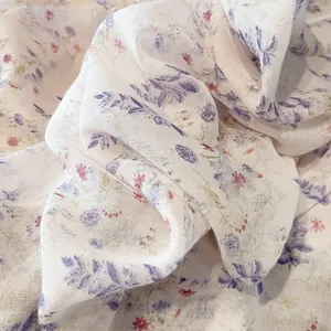 Close-up of lightweight floral scarf fabric with purple leaves and red flowers