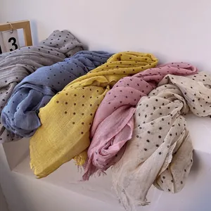 Lightweight linen-blend scarf with colorful polka dots and natural fringe on a white background
