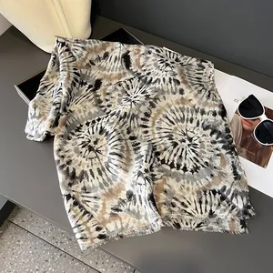 Vista piatta di una sciarpa tie-dye leggera con frange, occhiali da sole e borsa a mano