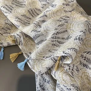 Detail shot of bohemian geometric print scarf featuring colorful tassels on cotton linen fabric