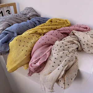 Detailed view of colorful polka dot linen scarves featuring delicate frayed fringe edges