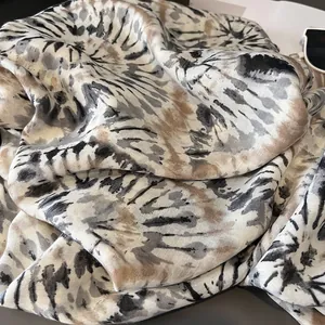 Dettaglio della sciarpa in seta tie-dye luccicante con pieghe e motivi eleganti