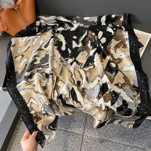 Close-up of artistic marble print linen scarf with black polka dot border and soft fringes