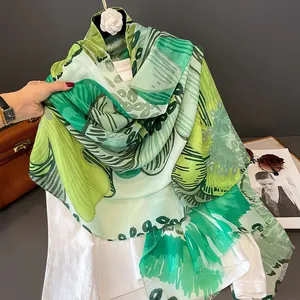 Détail d'un foulard en soie vert à imprimé géométrique avec des accessoires de mode élégants