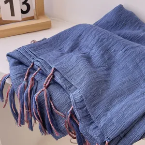 Close-up of deep blue cotton linen scarf with colorful fringe tassels and crinkle texture