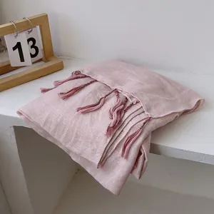 Close-up of light pink cotton linen shawl with delicate purple gradient tassel fringe