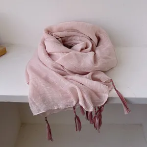 Close-up of pink linen scarf with delicate tassels and fine woven texture details